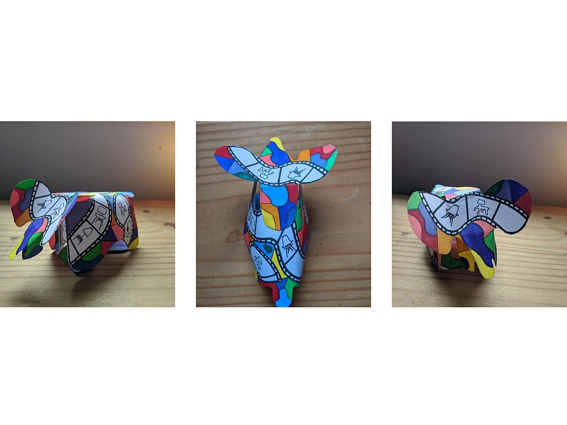 Three images of a three dimensional paper elephant from different angles decorated in with bright colored patterns and hand-drawn images of Eames chairs.
