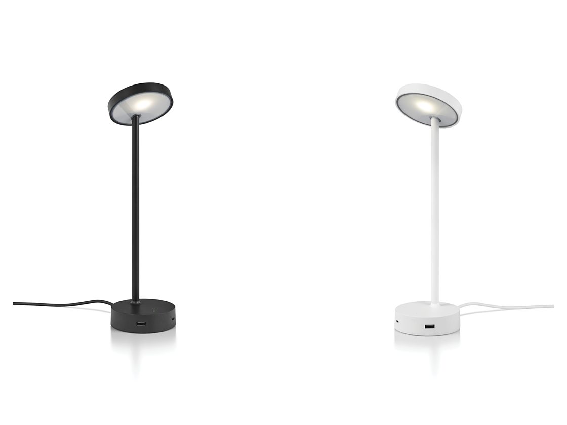 A lit up black CBS Lolly Personal Light facing a white Lolly lamp with a USB port showing.