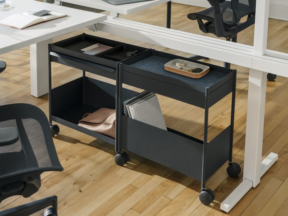 A graphite mobile OE1 shared-extended Storage Trolley, each side with open tops, a top drawer, and an open bottom shelf with the configuration mirrored.