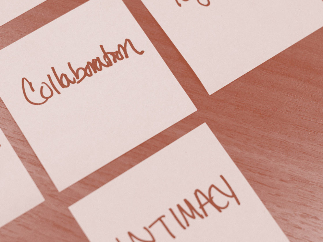 A photo of sticky notes grouped together that read collaboration, togetherness, and intimacy.
