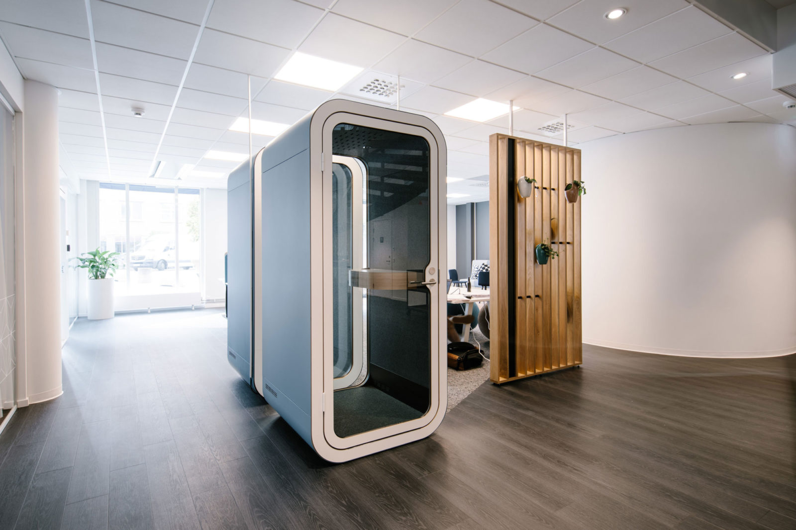 The interior of an office with two blue Framery O pods arranged next to each other to be used for private conversations.