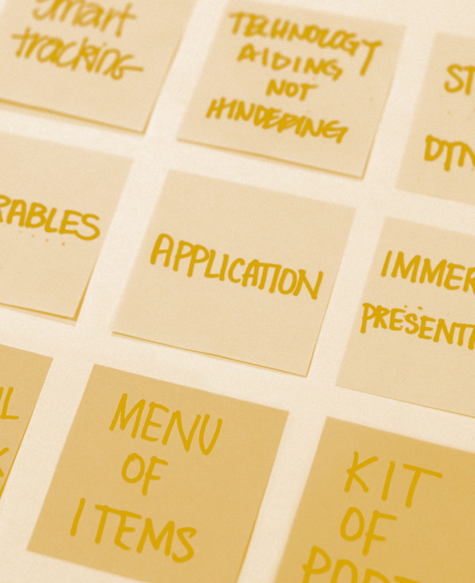 Sticky notes arranged in a grid filled with written ideas including "menu of items," "kit of parts," and "application."