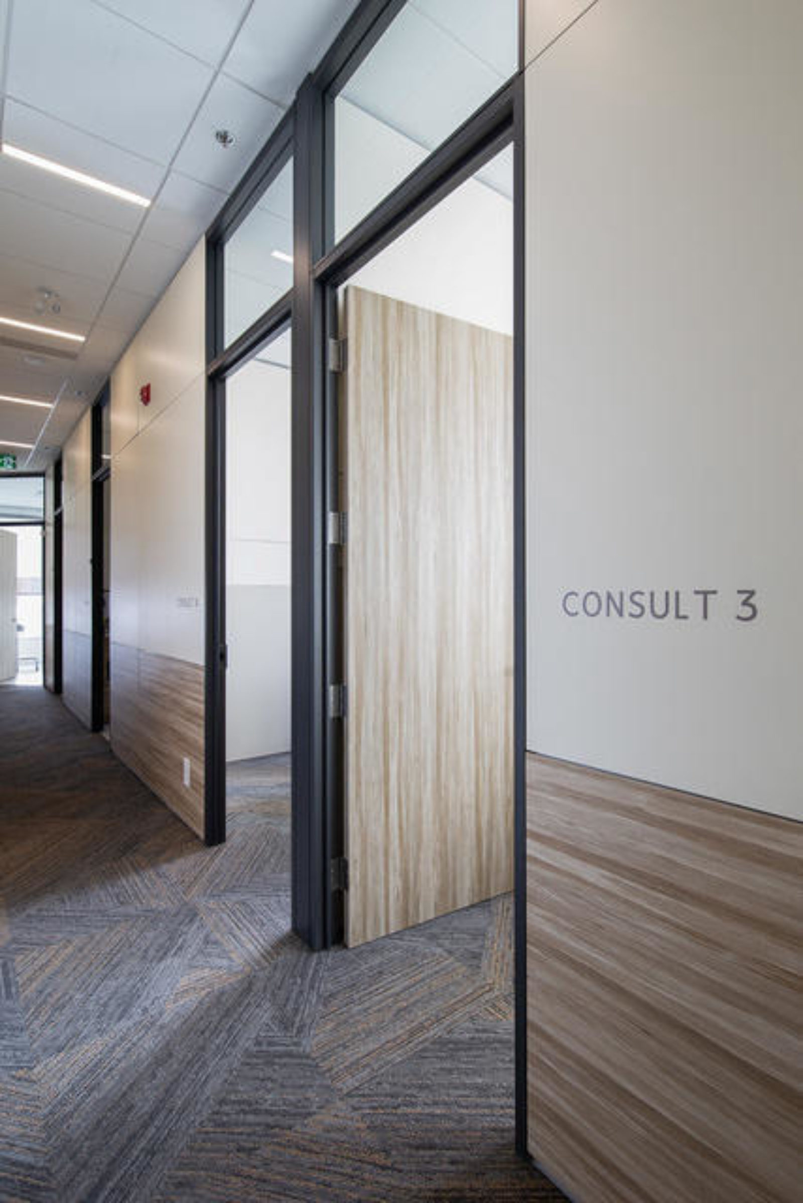 A hallway with patient rooms created used DIRTT prefabricated interior construction.