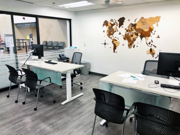 Two workstations with white sit to stand desks, Verus Task Chairs, Caper Guest Chairs, and monitors on Flo Monitor Arms.