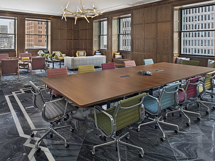 The fourth floor conference room of MarxModa's downtown headquarters with wood-paneled walls, marble floors, a long wooden conference table.