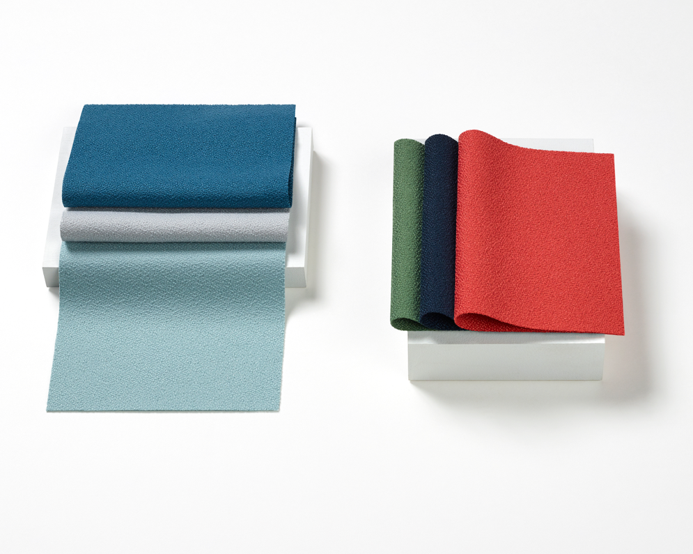 An image of Crepe fabric swatches on a white surface. Colors include blues, red, green, and grey.